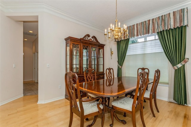 dining room with baseboards, light wood-type flooring, a chandelier, and ornamental molding