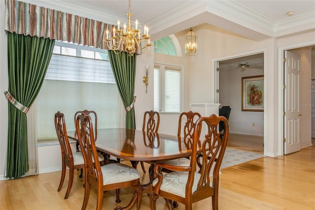 dining room featuring crown molding, light wood-style flooring, a notable chandelier, and baseboards