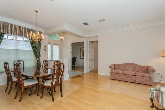 dining area with visible vents, ornamental molding, light wood-style floors, baseboards, and a chandelier