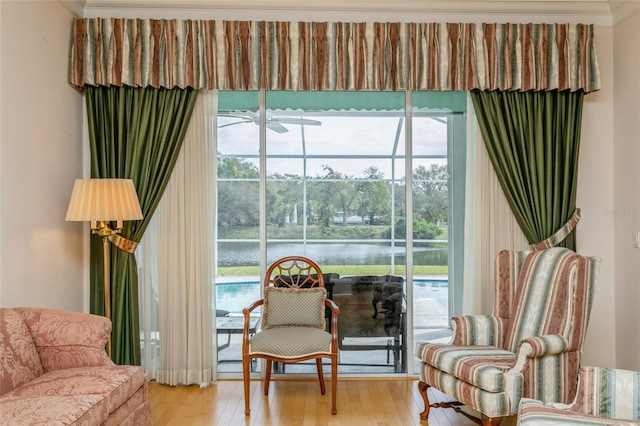 sitting room with plenty of natural light, a water view, and wood finished floors