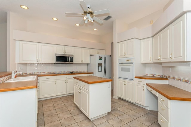 kitchen with light tile patterned floors, visible vents, white appliances, and a sink