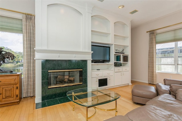 living room with light wood-type flooring, visible vents, recessed lighting, a fireplace, and baseboards