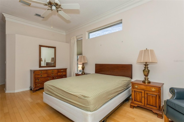 bedroom with visible vents, ornamental molding, a ceiling fan, light wood finished floors, and baseboards