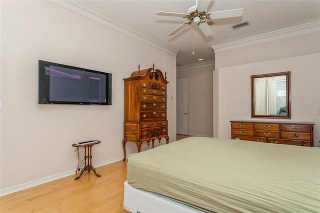 bedroom with visible vents, crown molding, light wood finished floors, baseboards, and ceiling fan