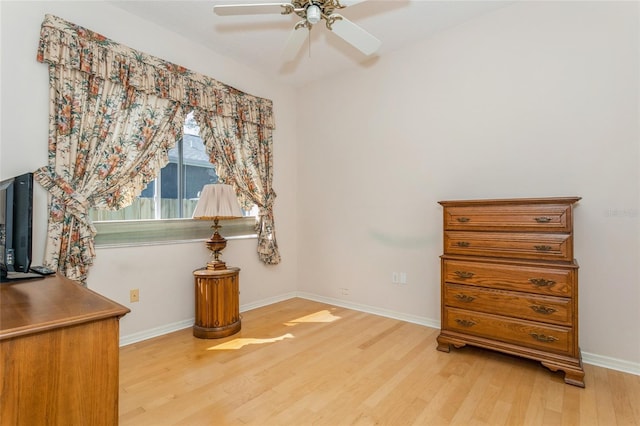 interior space featuring baseboards, light wood-style floors, and a ceiling fan