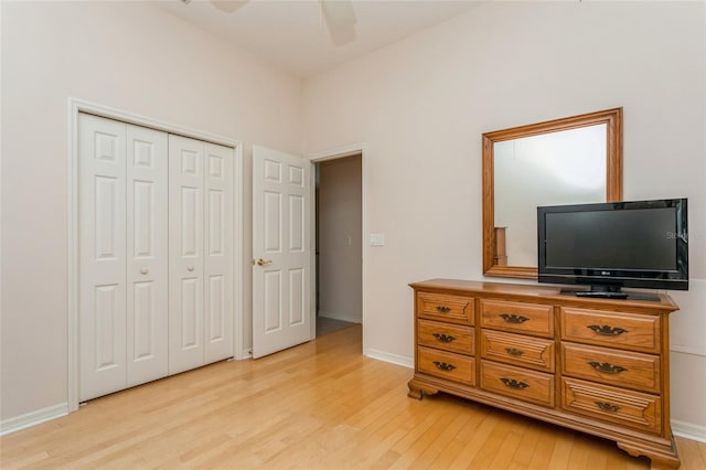 bedroom featuring baseboards, a closet, light wood finished floors, and ceiling fan