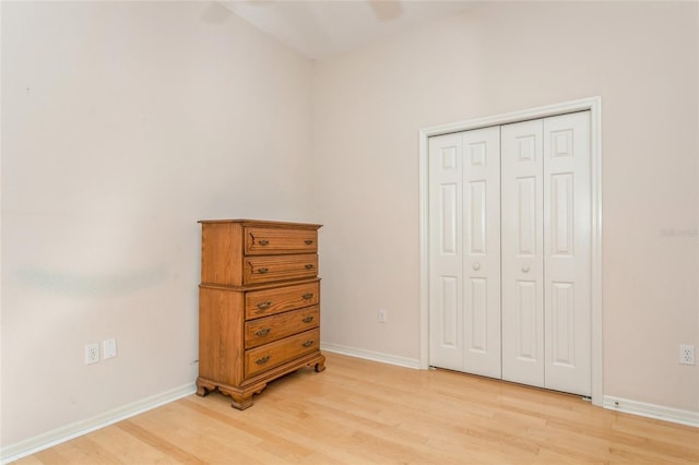 bedroom with a closet, baseboards, and light wood-style flooring