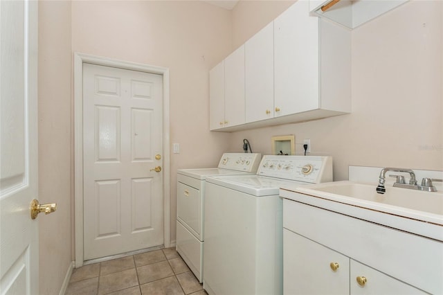 laundry area with baseboards, light tile patterned flooring, cabinet space, a sink, and independent washer and dryer