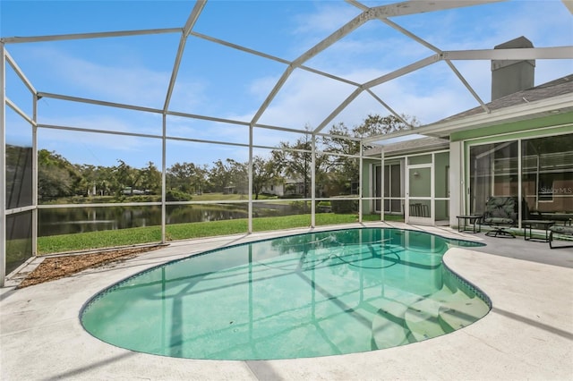 outdoor pool featuring a patio area, glass enclosure, and a water view