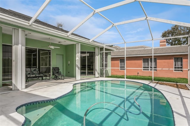 pool featuring a lanai, a ceiling fan, and a patio