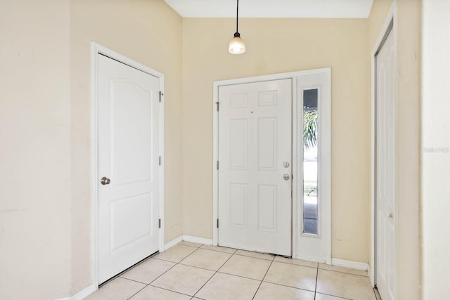 foyer entrance featuring light tile patterned floors and baseboards