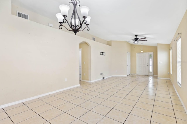 empty room with visible vents, ceiling fan with notable chandelier, arched walkways, light tile patterned floors, and lofted ceiling