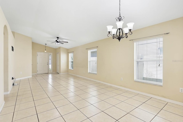 unfurnished room with light tile patterned flooring, ceiling fan with notable chandelier, baseboards, and lofted ceiling