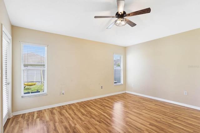 spare room with ceiling fan, baseboards, and light wood-style flooring