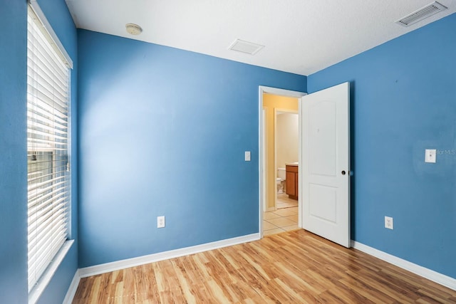 unfurnished room featuring visible vents, baseboards, and wood finished floors