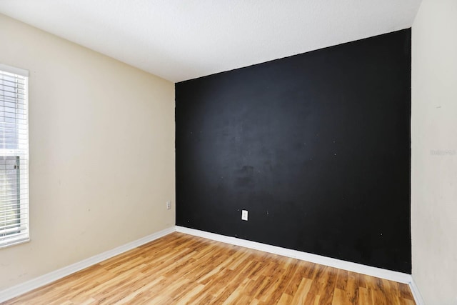 empty room featuring baseboards and light wood-style floors