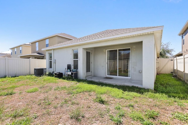 back of property with a patio, cooling unit, a yard, a fenced backyard, and stucco siding