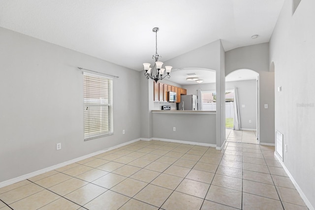 7233 Lumber Port Dr, Ruskin, FL 33573 - empty room featuring plenty of natural light, light tile patterned floors, a chandelier, arched walkways, and lofted ceiling