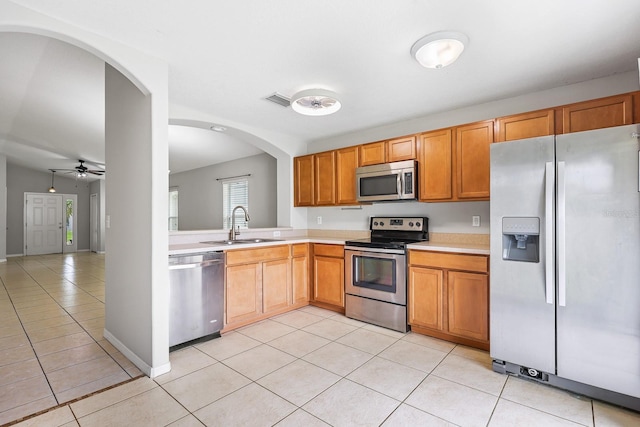 7233 Lumber Port Dr, Ruskin, FL 33573 - kitchen featuring appliances with stainless steel finishes, light tile patterned floors, light countertops, ceiling fan, and arched walkways