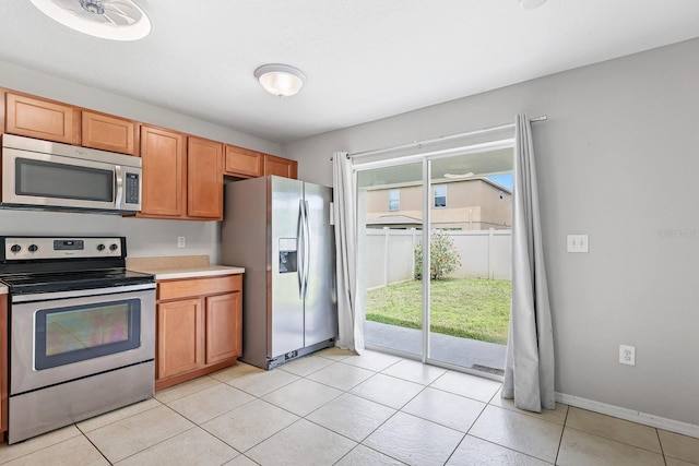 7233 Lumber Port Dr, Ruskin, FL 33573 - kitchen with appliances with stainless steel finishes, light tile patterned flooring, light countertops, and brown cabinetry