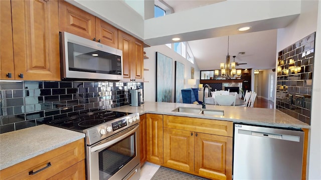 kitchen with backsplash, a peninsula, a notable chandelier, stainless steel appliances, and a sink