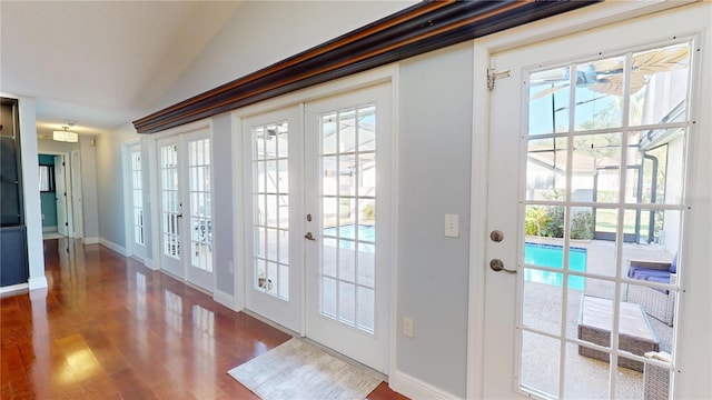 doorway to outside featuring french doors, lofted ceiling, baseboards, and wood finished floors