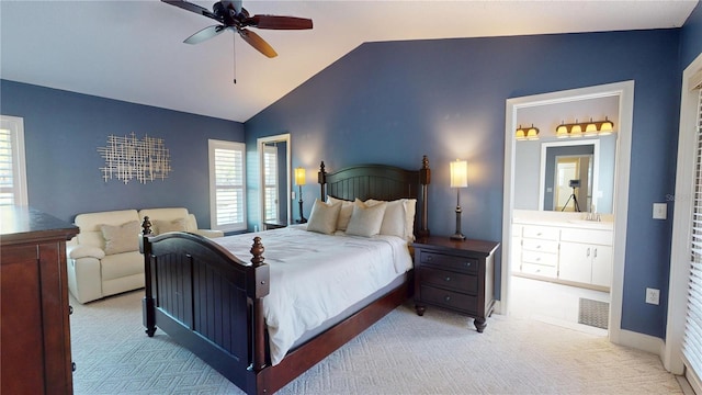 bedroom with a ceiling fan, baseboards, carpet floors, ensuite bath, and vaulted ceiling