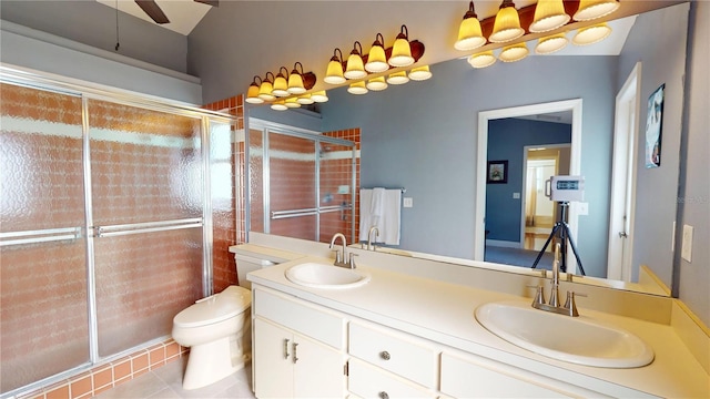 bathroom with a shower stall, toilet, double vanity, and a sink