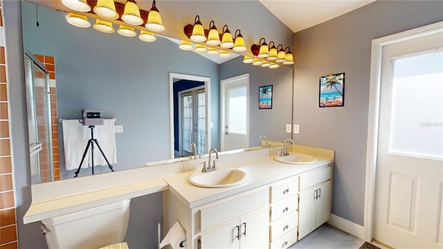 bathroom featuring a sink, baseboards, and double vanity