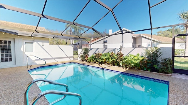 outdoor pool with glass enclosure, a patio, and fence