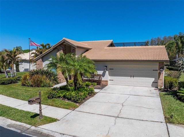 ranch-style home featuring a tiled roof, an attached garage, brick siding, and driveway