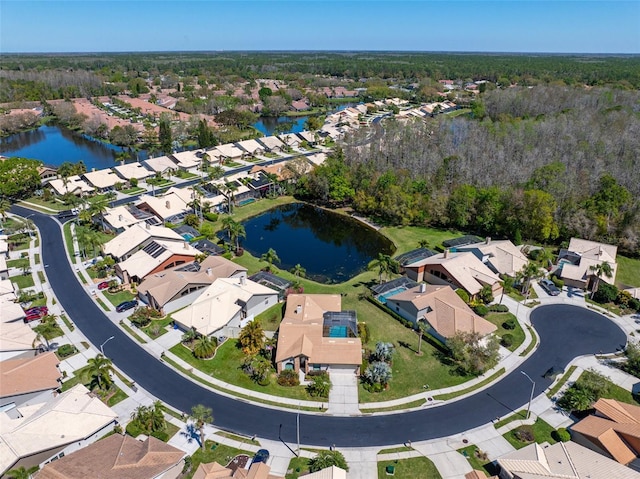 birds eye view of property with a residential view, a water view, and a view of trees