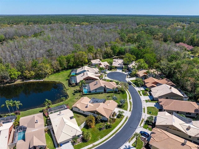 drone / aerial view with a residential view, a forest view, and a water view