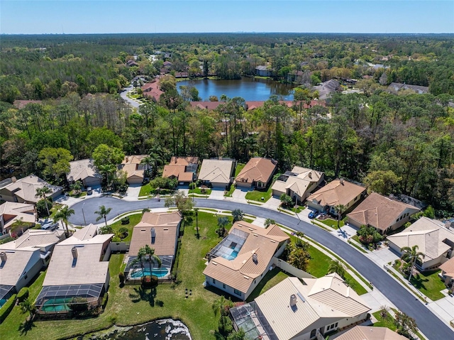 aerial view with a residential view, a view of trees, and a water view