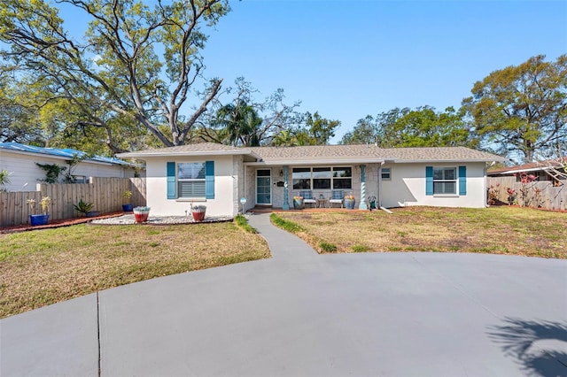 ranch-style home with stucco siding, a front lawn, and fence