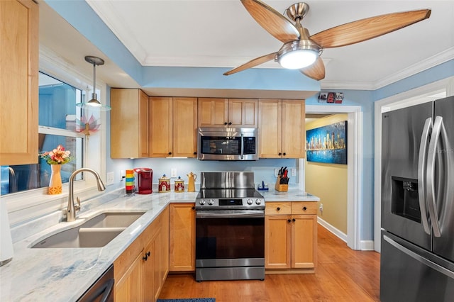 kitchen featuring ornamental molding, light stone countertops, stainless steel appliances, and a sink