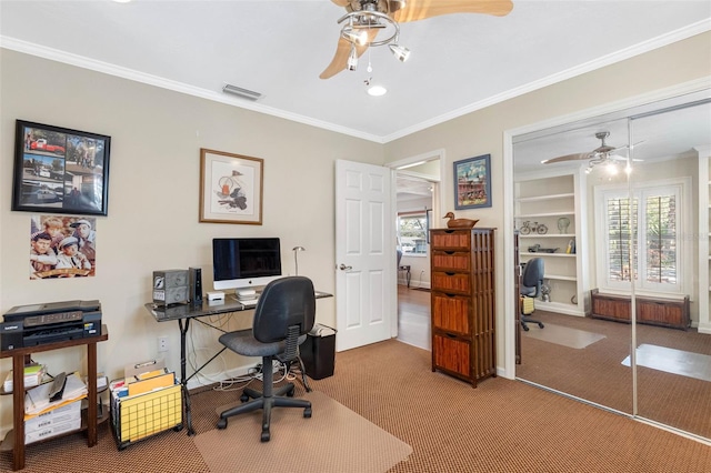 home office with visible vents, crown molding, ceiling fan, carpet, and built in features