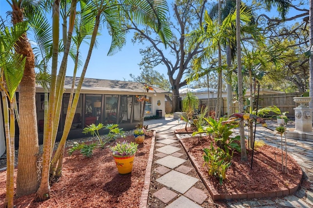 view of yard with a sunroom, a patio, and fence