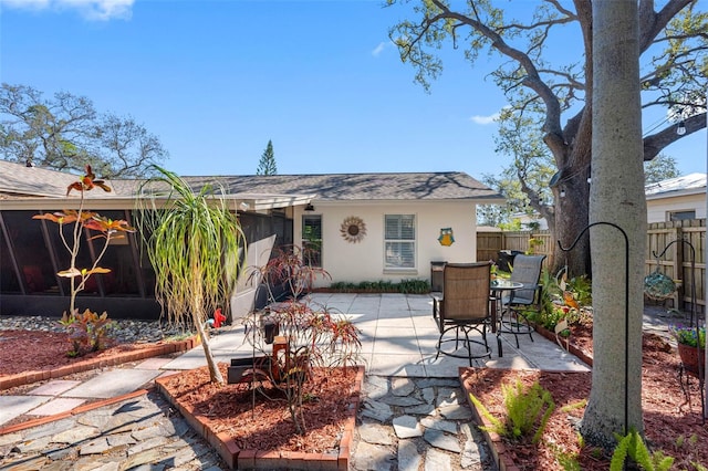 rear view of property featuring a patio, fence, and stucco siding