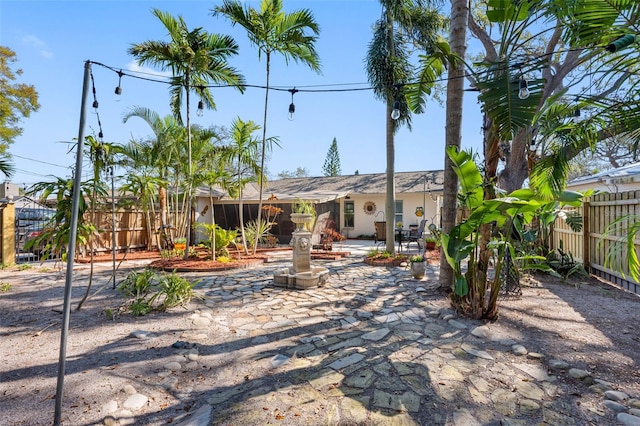 rear view of property with stucco siding, fence, and a patio area