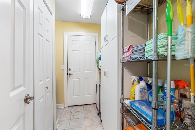 laundry room featuring light tile patterned floors and cabinet space