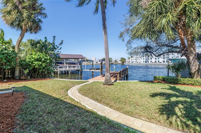 view of yard with a dock, a water view, and boat lift