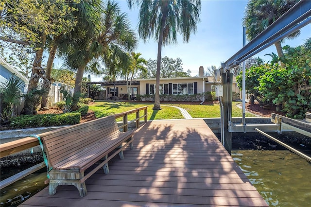 view of dock featuring boat lift, a yard, and a water view