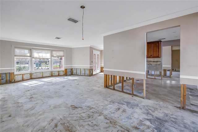 unfurnished room with visible vents, unfinished concrete floors, and crown molding