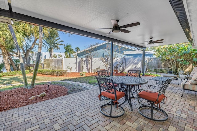 view of patio featuring outdoor dining space, a ceiling fan, and fence