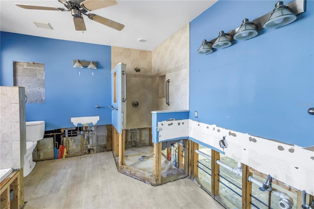 full bathroom featuring visible vents, toilet, a stall shower, wood finished floors, and ceiling fan