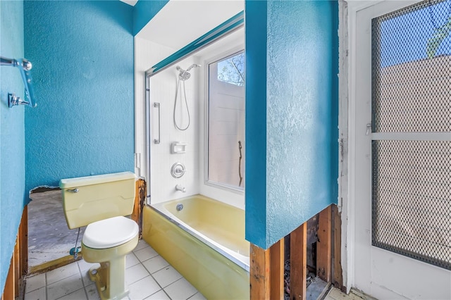 full bath with tile patterned flooring, toilet, a textured wall, and bathtub / shower combination