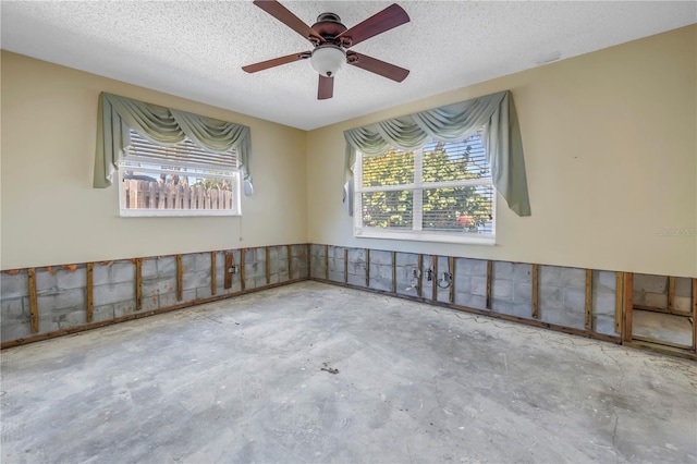 empty room with a textured ceiling and concrete flooring