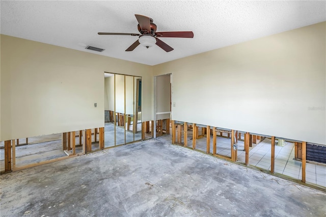 unfurnished room featuring visible vents, a textured ceiling, and concrete floors