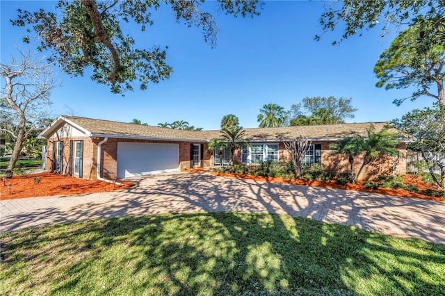 ranch-style home with brick siding, driveway, a front yard, and a garage